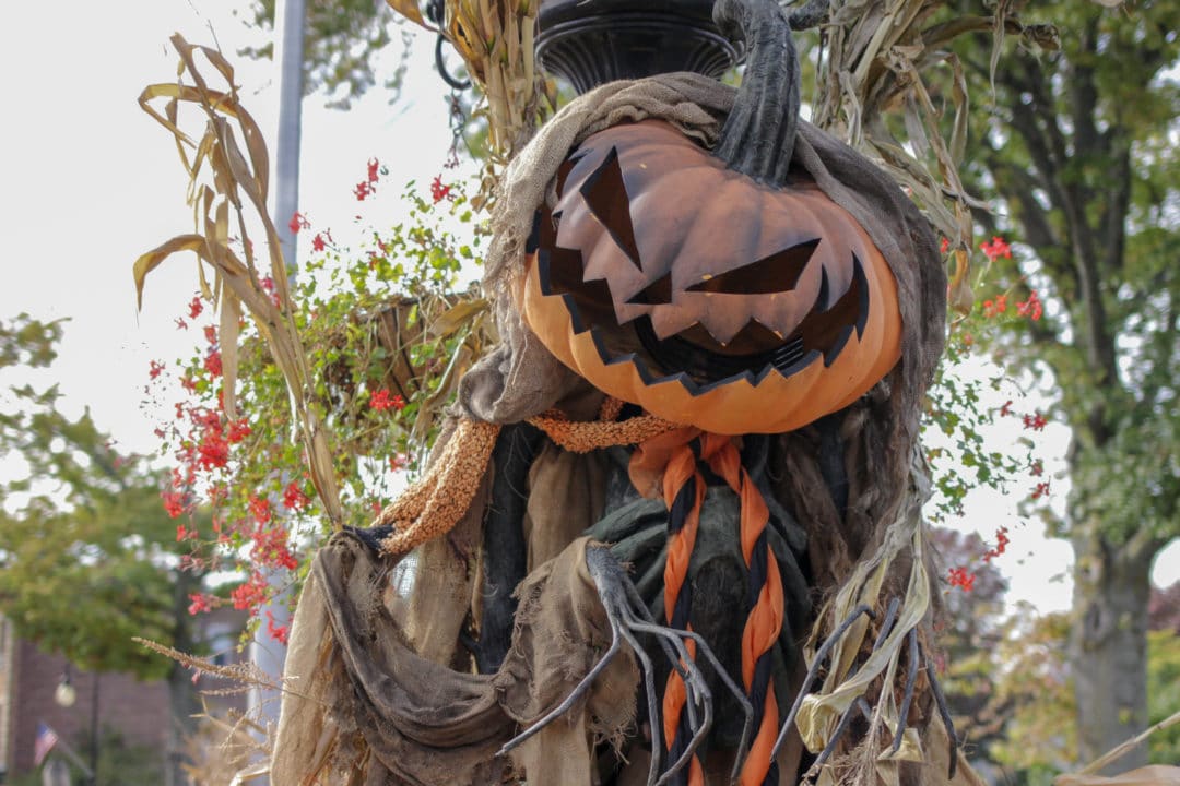 a carved jack o lantern head is tied to a pole