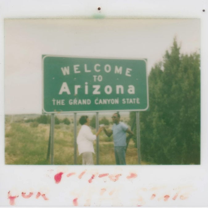 a couple toasts in front of a welcome to arizona sign