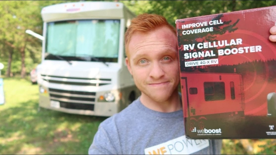 Man holding up an RV cellular signal booster