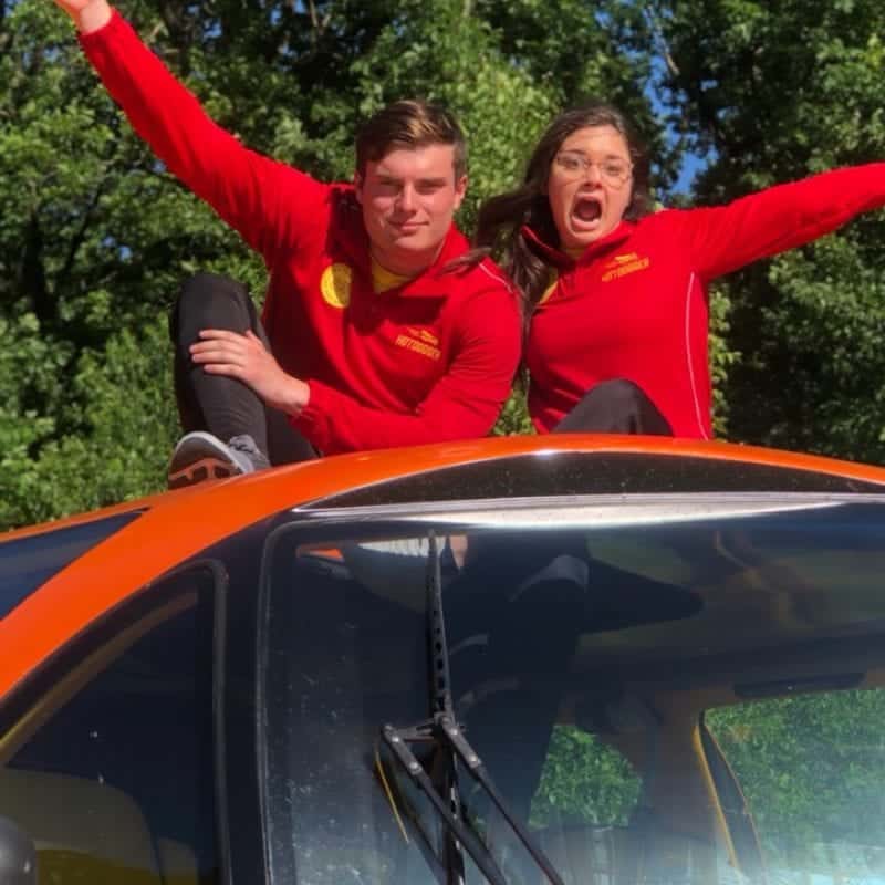 McMahon and Koemptgen pose on top of the wienermobile