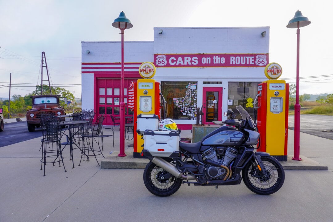 A motorcycle parked in front of a brightly colored vintage service station